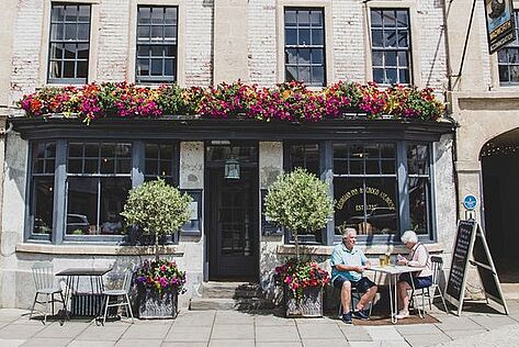 Customers sitting outside a Wadworth pub in the sunshine
